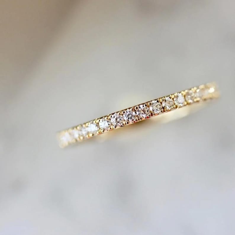 French pavé diamond band with .40ct GH/VS white round brilliant cut diamonds in 14k yellow gold. Floating pavé diamond ring with hand-cut v grooves for maximum sparkle. ¾ eternity band with solid gold bar for easy resizing. Available in 10k, 14k, and 18k solid gold in yellow, white, or rose. Customizable with lab-grown diamonds. Elegant stacking wedding band or minimalist engagement ring. Dainty, timeless, and handcrafted with luxe detail.