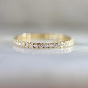 French pavé diamond band with .40ct GH/VS white round brilliant cut diamonds in 14k yellow gold. Floating pavé diamond ring with hand-cut v grooves for maximum sparkle. ¾ eternity band with solid gold bar for easy resizing. Available in 10k, 14k, and 18k solid gold in yellow, white, or rose. Customizable with lab-grown diamonds. Elegant stacking wedding band or minimalist engagement ring. Dainty, timeless, and handcrafted with luxe detail.
