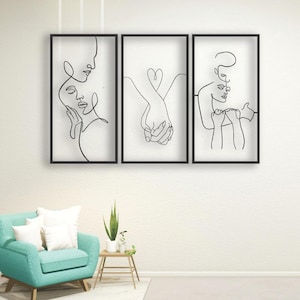 Puede incluir: Un tríptico de arte mural enmarcado con dibujos lineales minimalistas. Cada pieza enmarcada en negro representa una escena romántica diferente: dos rostros, manos entrelazadas formando un corazón y dos figuras abrazándose. El arte cuelga sobre un sillón turquesa.