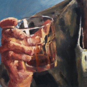 May include: A hand holding a clear glass with a brown liquid inside. The hand is wearing a brown jacket.