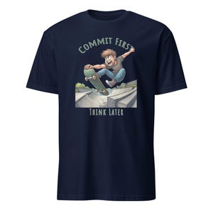 Op de afbeelding: Donkerblauw T-shirt met een cartoonillustratie van een persoon die skateboarden in een skatepark. De tekst "COMMIT FIRST THINK LATER" is op het T-shirt gedrukt.
