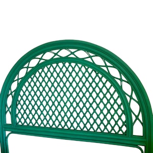 May include: A green wicker headboard with a diamond-shaped lattice design. The headboard is arched at the top and has a simple, elegant design.