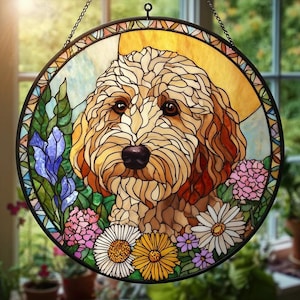 May include: Round stained glass window featuring a dog's portrait surrounded by colorful flowers and foliage. The dog has brown eyes and a black nose. The flowers include daisies, irises, and hydrangeas in shades of white, yellow, pink, and purple.