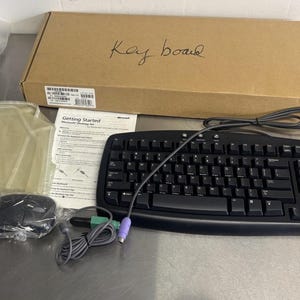 May include: A black Microsoft keyboard with a mouse, cables, and a cardboard box labeled "Keyboard." The box also contains a "Getting Started" guide. The keyboard has a standard layout.