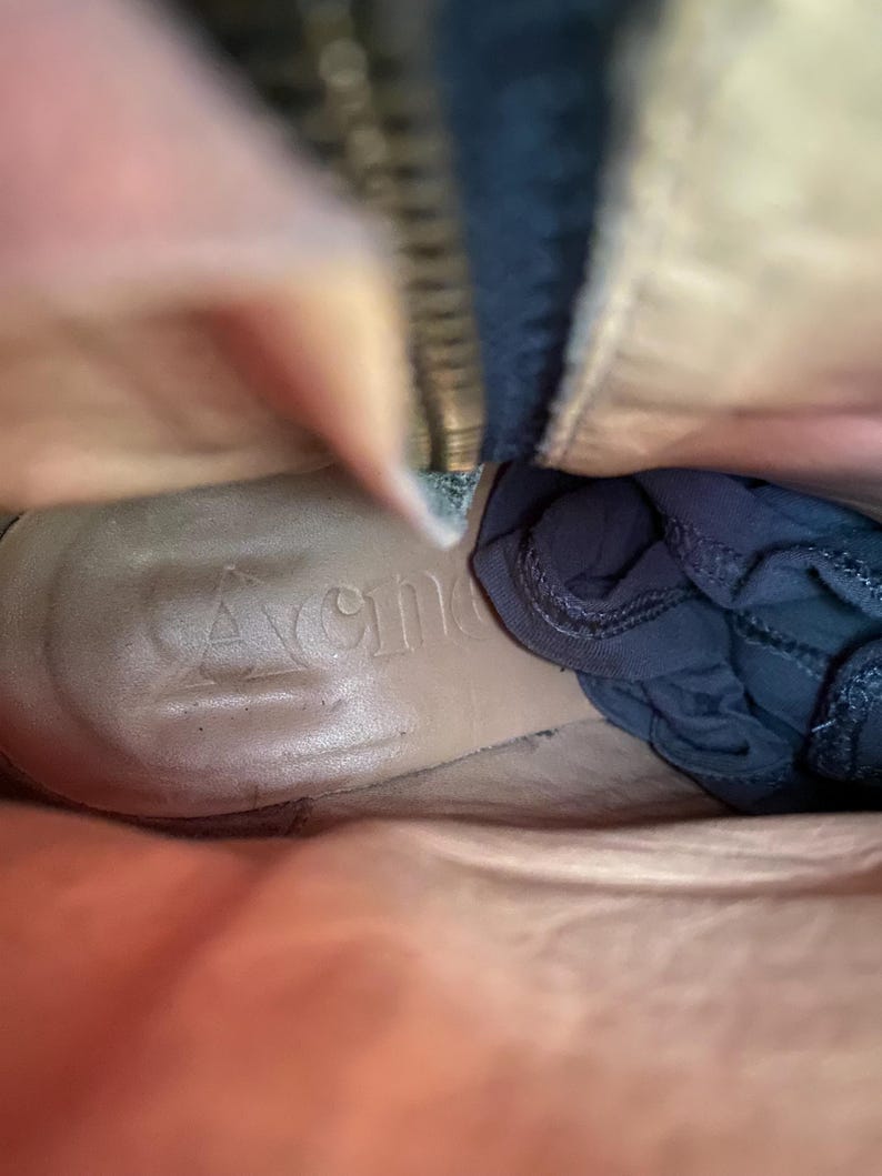 May include: Interior view of a tan leather boot with a dark blue fabric inside. The word "Avenger" is embossed on the insole. A zipper is visible along the side of the boot.