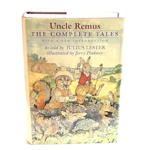 May include: A hardcover book titled "Uncle Remus The Complete Tales" with illustrations by Jerry Pinkney. The cover features a colorful illustration of anthropomorphic animals in a rural setting. The book's spine is visible, and the overall aesthetic is vintage.