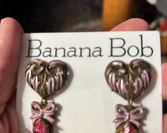 Pendientes Banana Bob con forma de corazón esmaltado, lazos esmaltados en rosa y una navette rosa de 2 pulgadas.