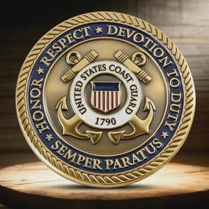 May include: A gold-colored United States Coast Guard commemorative coin. The coin features the Coast Guard emblem, anchors, and the text "HONOR, RESPECT, DEVOTION TO DUTY, SEMPER PARATUS" and "1790". The coin has a blue and white border.