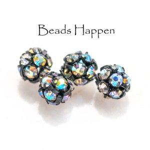 May include: Four iridescent black and silver round beads with a faceted design.  The beads are about 1/2 inch in diameter.  The beads are on a white surface.  "Beads Happen" is written in black text above the beads.