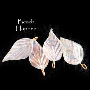 May include: Four iridescent glass leaf-shaped beads with gold jump rings. The beads have a white, opalescent finish and are perfect for jewelry making.