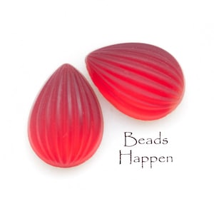 May include: Two red, teardrop-shaped beads with a ribbed texture. The beads are on a white background with the text "Beads Happen" written below them.