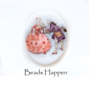 May include: A white oval ceramic cameo with a painted scene of a couple in 18th-century clothing. The woman is wearing a red and white dress and the man is wearing a purple jacket and white pants. The cameo is on a white background.