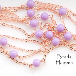 Puede incluir: Primer plano de un collar con una cadena de oro rosa y pequeñas cuentas redondas de color lavanda. El texto "Beads Happen" es visible. Este collar es probablemente para la fabricación de joyas o artesanía.