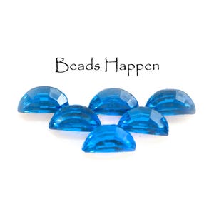 May include: Six faceted, half-dome shaped, bright blue beads are arranged on a white background. The text "Beads Happen" is above the beads. These beads are suitable for jewelry making and crafting.