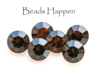 Puede incluir: Seis cuentas de vidrio facetadas de color marrón oscuro sobre un fondo blanco. El texto "Beads Happen" está escrito encima de las cuentas.