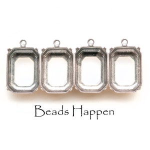Puede incluir: Cuatro engastes de metal plateados con forma rectangular y un bucle en la parte superior. Los engastes están diseñados para sujetar una piedra cabujón u otro adorno.
