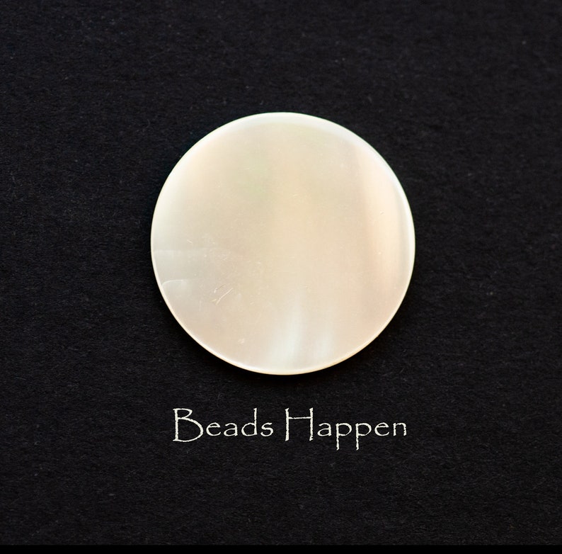 May include: A white, round, smooth, iridescent, mother of pearl bead.