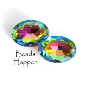 May include: Two iridescent oval-shaped glass beads with a rainbow effect. The beads are on a white background with the text "Beads Happen" below them.