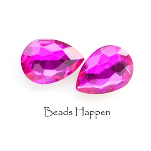 Puede incluir: Dos cuentas de cristal de forma de l&aacute;grima rosa con superficies facetadas. Las cuentas est&aacute;n sobre un fondo blanco. Beads Happen est&aacute; escrito debajo de las cuentas.