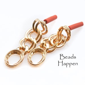 Puede incluir: Pendientes de cadena de oro con detalles rojos. Los pendientes están hechos de una cadena gruesa con eslabones ovalados grandes. Los pendientes están unidos a un poste rojo.