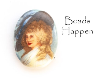 May include: Oval ceramic bead featuring a painted image of a woman in a blue hat and white dress. The bead has a glossy finish.