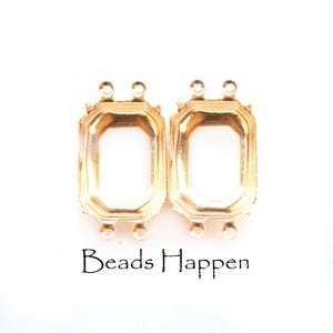 May include: Two gold-toned rectangular metal settings for jewelry, each featuring four small loops for attachment, two at the top and two at the bottom. The text "Beads Happen" is printed in black below the two metal components.