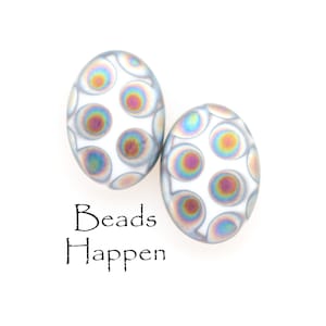 May include: Two iridescent white oval beads with a pattern of smaller iridescent circles. The beads have a subtle shimmer and are perfect for jewelry making.
