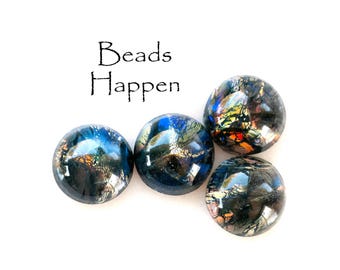 May include: Four iridescent glass beads with a dark blue, black, and gold color scheme. The beads have a mottled, textured surface and are arranged in a row on a white background. The text "Beads Happen" is written above the beads.