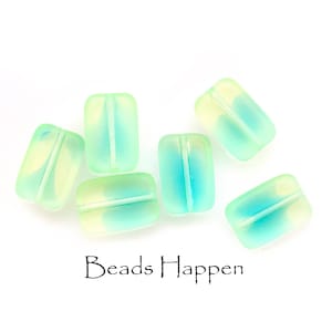 May include: Six light green and blue glass beads with a white stripe down the center. The beads are rectangular in shape and have a frosted finish.