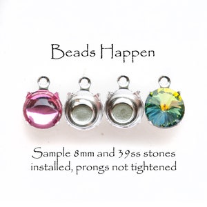 May include: Four silver settings for setting stones, with three stones already set. The stones are 8mm and 39ss. The stones are pink, clear, and green. The text "Beads Happen" is at the top of the image. The text "Sample 8mm and 39ss stones installed, prongs not tightened" is at the bottom of the image.