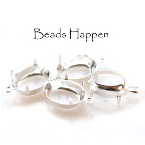 May include: Four silver oval-shaped bezel settings with prongs and a jump ring. The bezels are designed to hold a cabochon stone.