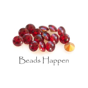 May include: A close-up of a pile of red glass beads, with one gold bead in the foreground. The text "Beads Happen" is written below the beads.