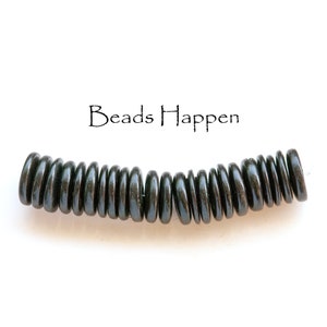 Op de afbeelding: Een streng zwarte, ronde kralen, gerangschikt in een gebogen vorm. De kralen zijn glad en glanzend, met een lichte glans. De tekst "Beads Happen" staat boven de kralen.