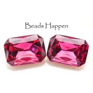 May include: Two deep red, faceted, rectangular glass beads.  The beads are approximately 1 inch long and 1/2 inch wide.  The beads have a slight pink hue.
