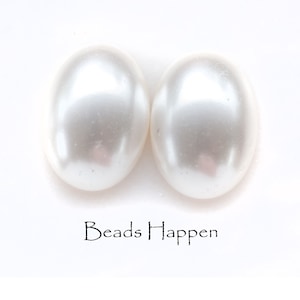 May include: Two white oval-shaped pearl beads.