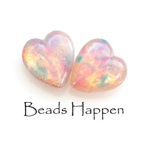 May include: Two iridescent pink heart-shaped glass beads with gold and green flecks. Beads Happen.