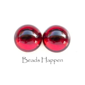May include: Two round, red glass beads. The beads are smooth and shiny.