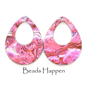 May include: Two teardrop-shaped earrings with a marbled pink and white pattern. The earrings have a dark outline and a small hole at the top for hanging. The text "Beads Happen" is at the bottom.