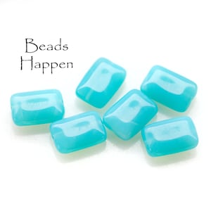May include: Six turquoise blue rectangular glass beads. The beads are smooth and glossy.