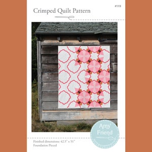 May include: A quilt pattern featuring a geometric design with pink, orange, and black shapes on a white background. The quilt is displayed against a wooden wall. The pattern is titled "Crimped Quilt Pattern" and is numbered #119. The finished dimensions are 42.5 inches by 51 inches. The pattern is described as "Foundation Pieced".