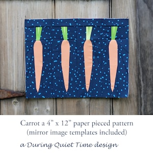 Op de afbeelding: Een papier-gepatcht patroon voor een 10 cm x 30 cm wortelontwerp. Het patroon is op een blauwe achtergrond met witte stippen en toont vier oranje wortels met groene toppen.