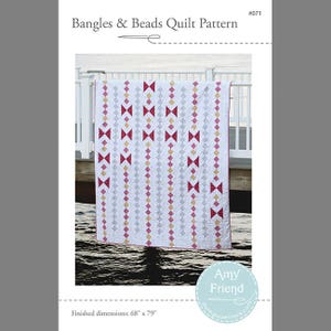 May include: A quilt pattern design featuring a white background with rows of red, gold, and gray geometric shapes. The quilt is hanging on a white railing over a body of water. The pattern is titled "Bangles & Beads Quilt Pattern #071" and the finished dimensions are 68 inches by 79 inches.