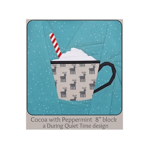 Pode incluir: Um design de bloco de colcha de papel com peças que representa uma caneca de chocolate quente com chantilly e um canudo vermelho e branco listrado. A caneca é decorada com um padrão de renas e o fundo é azul turquesa com pontos brancos. O texto "Cocoa with Peppermint 8" block a During Quiet Time design" está abaixo da imagem.