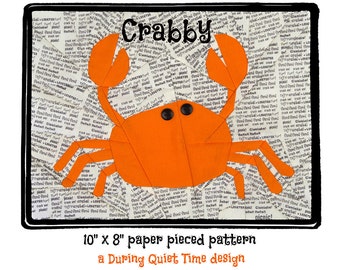 Könnte beinhalten: Ein Papier-Patchwork-Muster für einen Krebs, genannt "Crabby", auf weißem Hintergrund mit schwarzem Text. Das Muster ist 25,4 cm x 20,3 cm groß und ein Design von During Quiet Time.