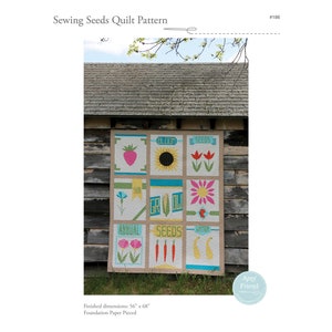 Pode incluir: Um padrão de colcha com um design de patchwork de nove quadrados com um tema de jardim. Cada quadrado tem uma imagem diferente, incluindo um morango, um girassol, tulipas, uma flor, cenouras, peras e texto que diz "Bloom", "Seeds", "Sun", "Grow", "Annual", "Seeds", e "Water". A colcha está pendurada em uma porta de celeiro de madeira. A colcha mede 142,2 cm por 172,7 cm e é feita com papel piquete.