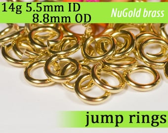 May include: A pile of 14 gauge brass jump rings, 5.5mm inside diameter and 8.8mm outside diameter. The rings are gold in color and are arranged in a random pattern. The text "NuGold brass" is visible in the image.