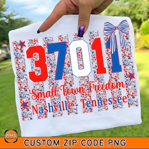 May include: White t-shirt with a patriotic design featuring the zip code 3701, the words "Small Town Freedom Nashville Tennessee", and a red, white, and blue bow. The design includes red and blue stars and floral patterns.