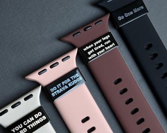 Puede incluir: Primer plano de cuatro correas de reloj coloridas. Las correas son blancas, rosas, marrones y negras. Cada correa tiene un acento metálico con texto motivacional: "You Can Do Hard Things", "Do It For The Strava Kudos", "When your legs get tired, run with your heart" y "Go One More".