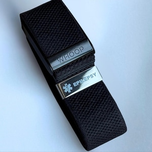 May include: Black woven wristband with silver metal clasps. The top clasp reads "WHOOP" and the bottom clasp reads "EPILEPSY" with a medical symbol. The band is designed for medical identification.