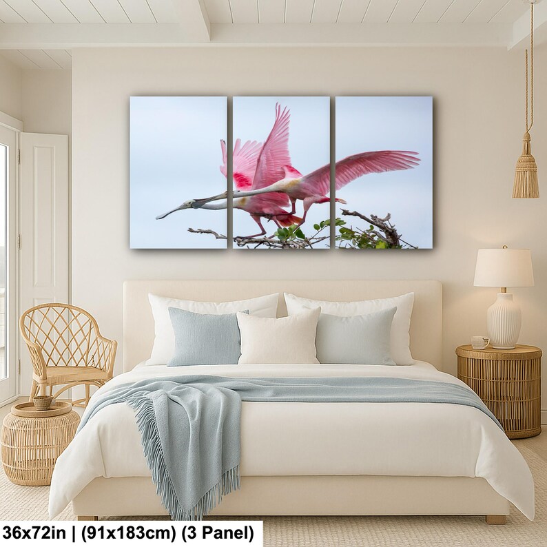 a bedroom with a large bed, a wicker chair, and a painting of a pink bird perched on a branch.